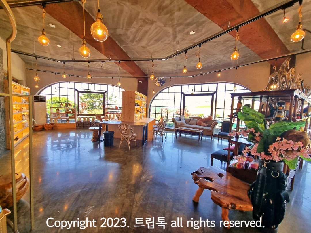 나무와 노란 불빛으로 꾸며진 카페에 나무 의자와 테이블