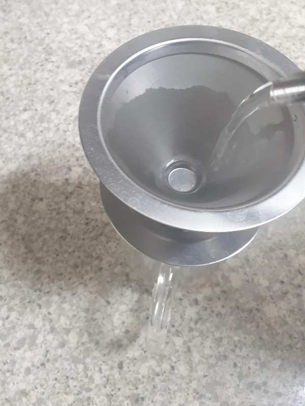 테이블 위에 있는 다이소 메탈 메쉬 드리퍼를 린싱 중이다.