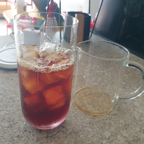 테이블에 컵과 비이커(서버)가 보인다. 컵에는 얼음과 커피가 담겨있다.