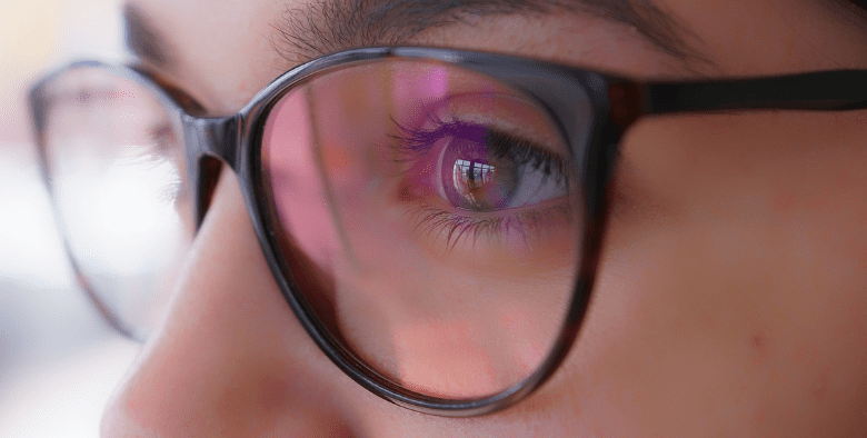 안경을 쓴 여성이 먼 곳을 바라보고 있다