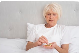 폐경 후 여성이 치료약을 복용하려고 하고 있다.