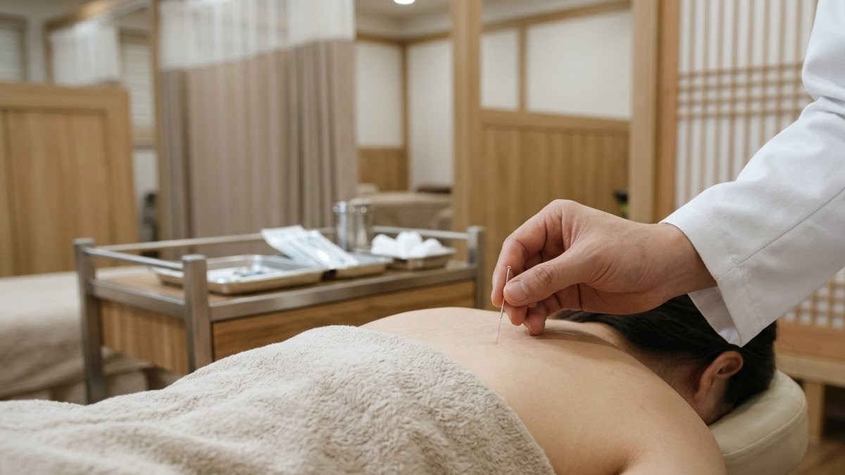 한의원 치료실에서 어깨 주변에 침 치료를 받는 모습