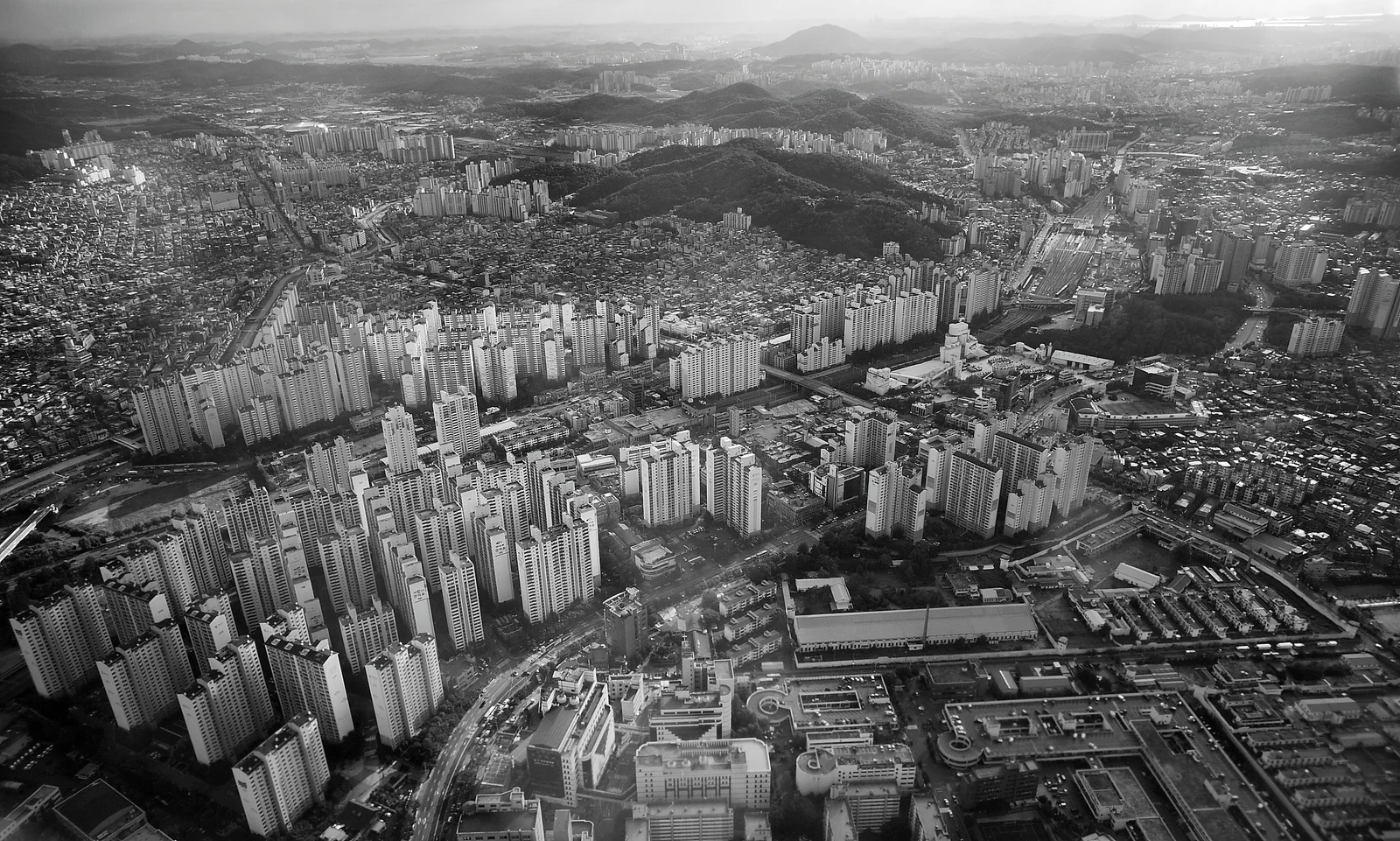 여러 동의 고층 주거 건물과 주변 토지를 함께 담은 서울의 흑백 조망 사진
