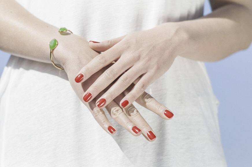 손등이 가려운 젋은 여성이 손을 만지고 있는 모습