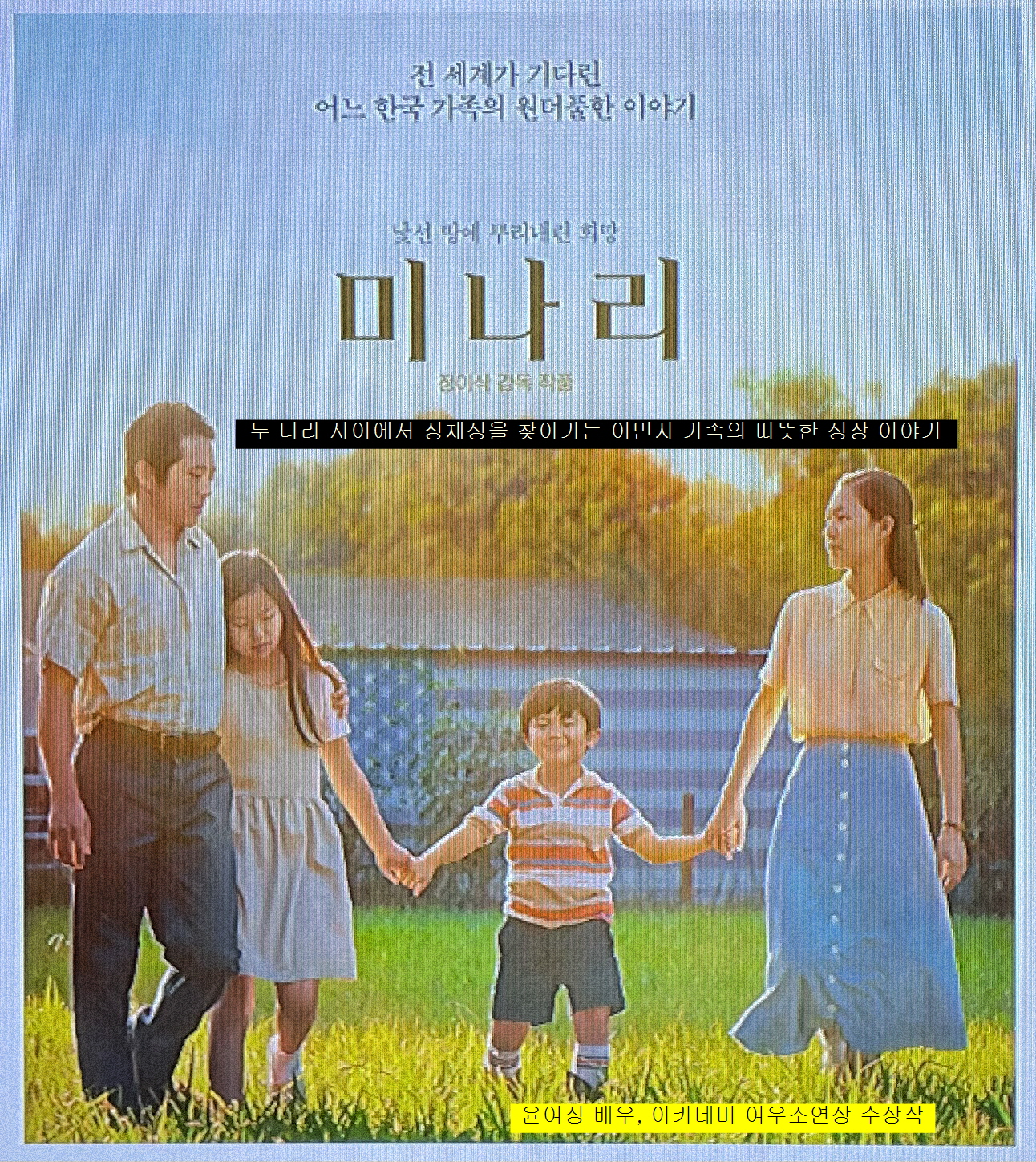 영화 미나리 포스터-이민자 가족 네명이 전면에 손에 손을 잡고 서있음-왼쪽 부터 아빠 딸 아들 엄마의 순서임-여름옷을 입고 있음-뒷편으로 미국성조기가 새겨진 담벼락이 보임