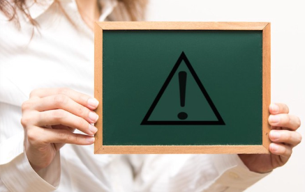 주의 마크가 그려진 칠판을 가진 사람.