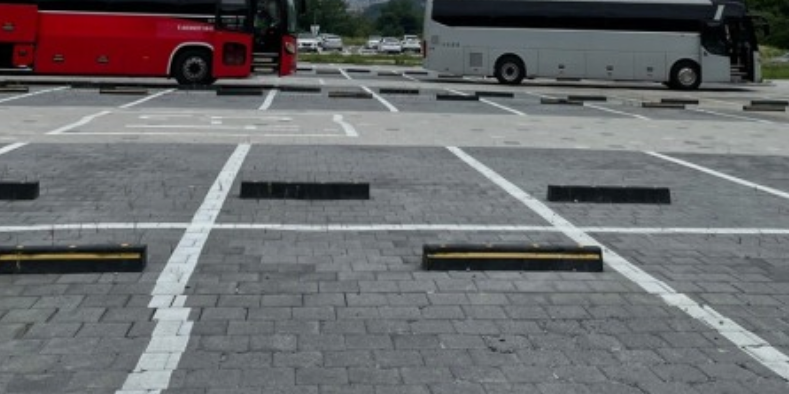 주차장에 버스와 자동차가 있는 모습 그리고 빈 주차공간