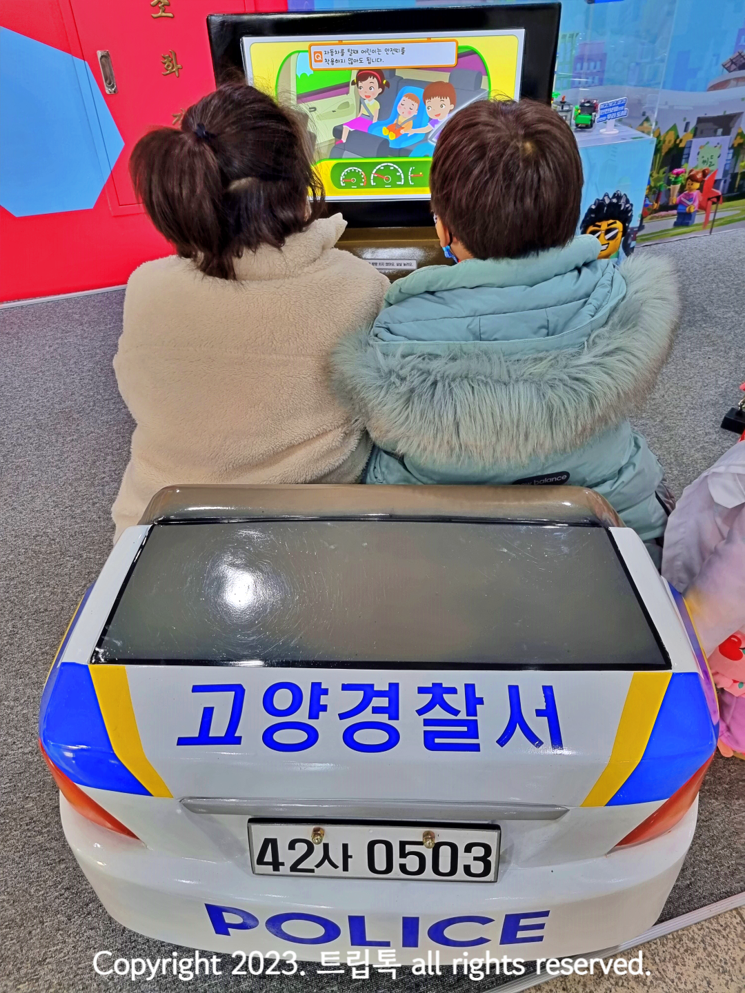 고양 어린이 경찰서라고 적힌 소형 경찰차를 타고 있는 아이들