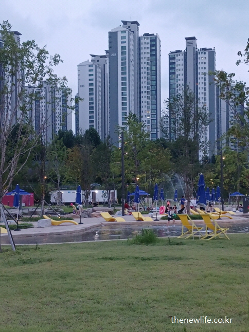 고층 아파트 배경과 함께 어우러진 썬베드 구역 &ndash; 도심 속 잠실 한강공원 물놀이장 전경