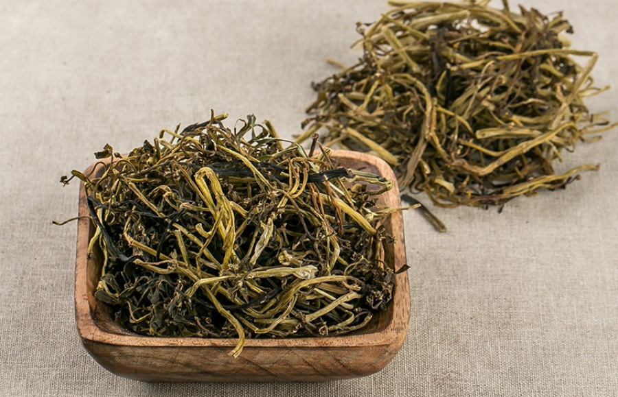 야생에서 채취를 한 쇠비름(장명채, 마치현)을 잘 세척한 후에 바싹 말린 것을 회색 바닥 위에 네모난 나무 그릇에 가득 담아두고 그 옆에 바닥에도 한움큼 놓아두고 찍은 사진