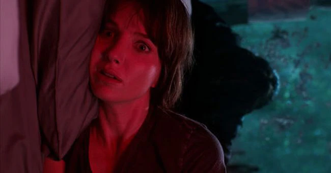 침대에 누워서 놀란 모습을 보이는 여성의 모습