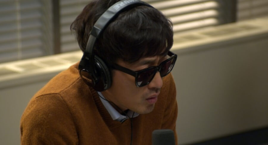 선글라스를 낀 채 라디오를 진행하고 있는 윤영화 역의 하정우