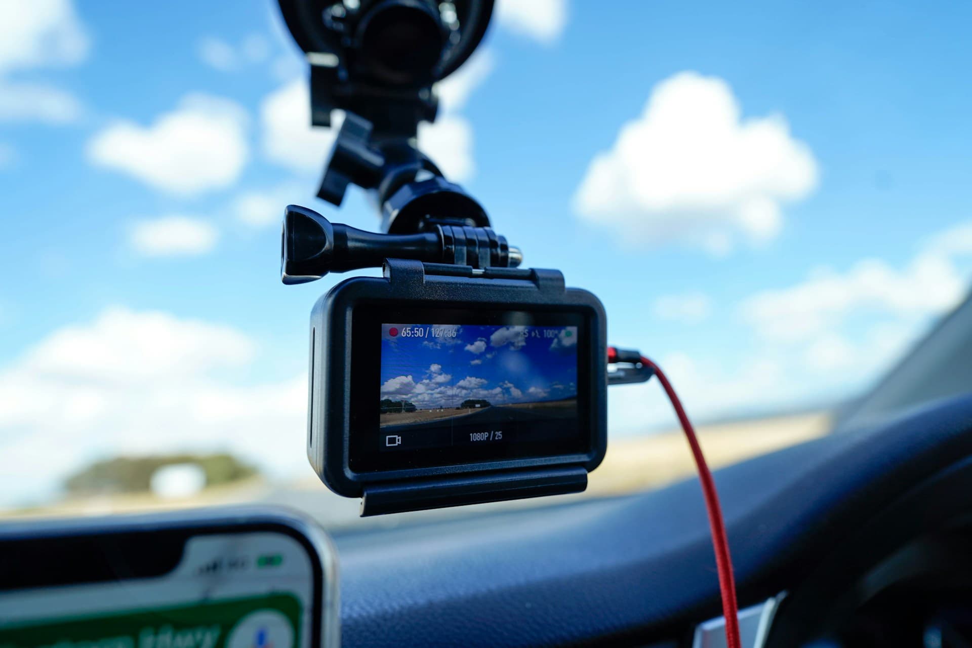 전면 유리에 장착된 블랙박스 화면에 주행 중 하늘과 도로가 녹화되는 모습