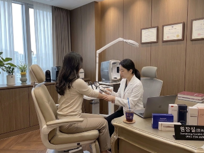 피부과 진료실에서 의자가 여성 환자를 진찰하는 모습