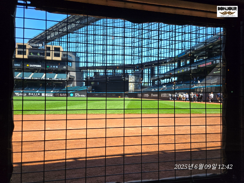 에스콘필드 도코모 클럽 라운지에서 창문 너머로 본 경기장 전경과 경기장 투어중인 사람들