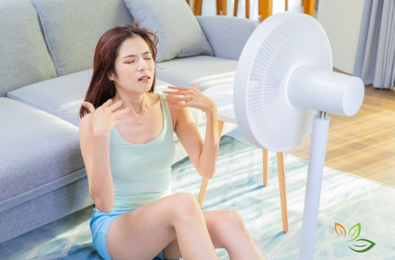 여름철 더위로 선풍기 바람을 쐬며 체온을 낮추려는 여성의 모습, 열대야 대처법 VIA CANVA
