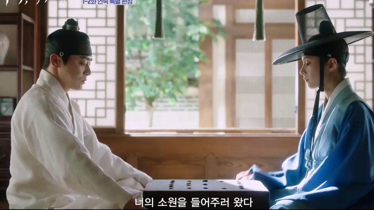 세작-
한옥 방안 흰한복을 입은 조정석과 맞은편 파란색 남자한복에 남자갓을 쓴 신세경이 함께 바둑을 두는 이미지