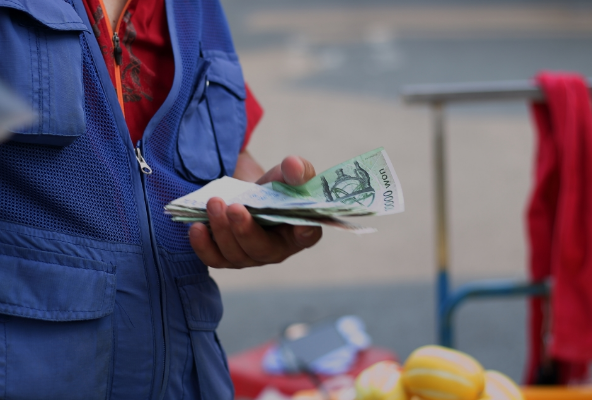 한 상인이 만원권 지폐를 잔뜩 쥐고 있다.