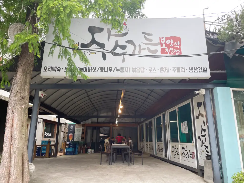 흰색 간판에 장수가든이라고 쓰여져 있으며 보양식 전문점이라고 빨간색이라고 쓰여있다