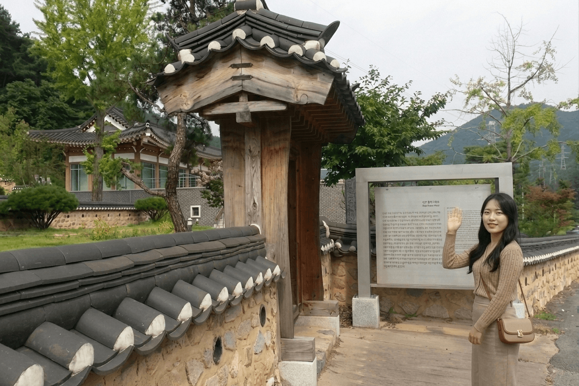 대구 녹동서원 회색 기와를 올린 전통 돌담장과 목조 문, 옆에 녹동서원 안내판이 세워져 있고 뒤편으로 한옥과 산이 보이는 맑은 날 전경