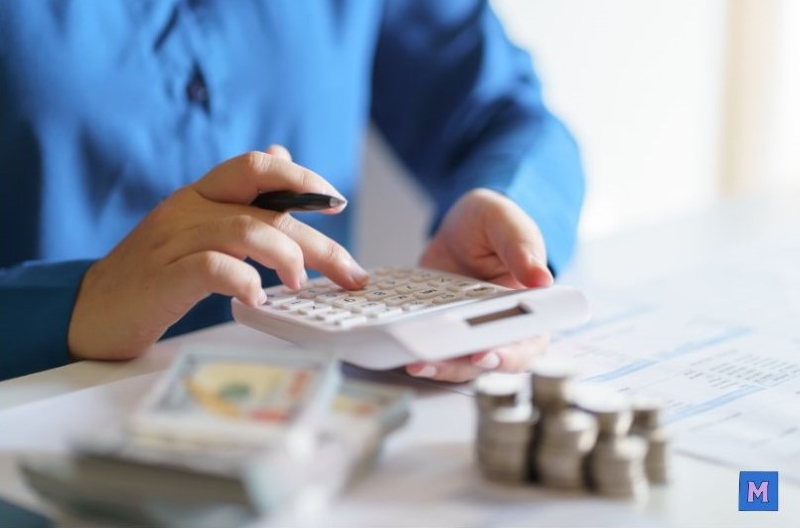 소상공인이 계산기로 긴급경영안정자금 대출 조건을 계산하고 있는 모습 via canva