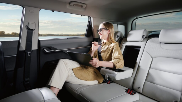 토레스EVX 뒷자리에서 업무보는 여자의 모습