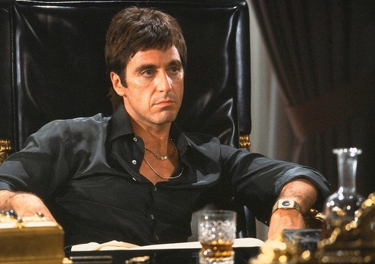브라이언 드 파르마 감독의 명작 스카페이스(Scarface, 1983)의 한 장면. 알 파치노(Al Pacino)는 쿠바 난민 출신에서 마이애미의 거대한 마약 왕국을 건설하는 광기 어린 주인공 토니 몬타나(Tony Montana) 역을 맡아, 영화 역사상 가장 뜨겁고 파괴적인 에너지를 뿜어냈다.