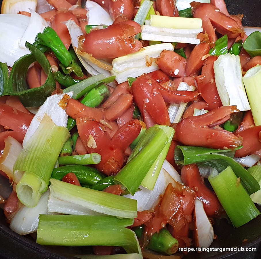 양념을 넣고 볶은 꽈리고추 소세지 볶음에 준비된 파를 넣는 사진