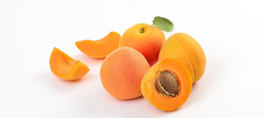 야생에서 채취를 한 살구를 하얀 바닥 위에 3개를 놓아두고 그 앞에는 살구를 반으로 잘라서 속에 씨가 보이게 한 상태로 놓아두고, 뒤에는 반으로 자른 살구를 다시 반으로 잘라 놓은 것을 2개 놓아두고 찍은 사진