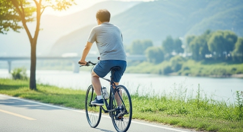 자전거를 타고 강변을 달리는 중년 남성