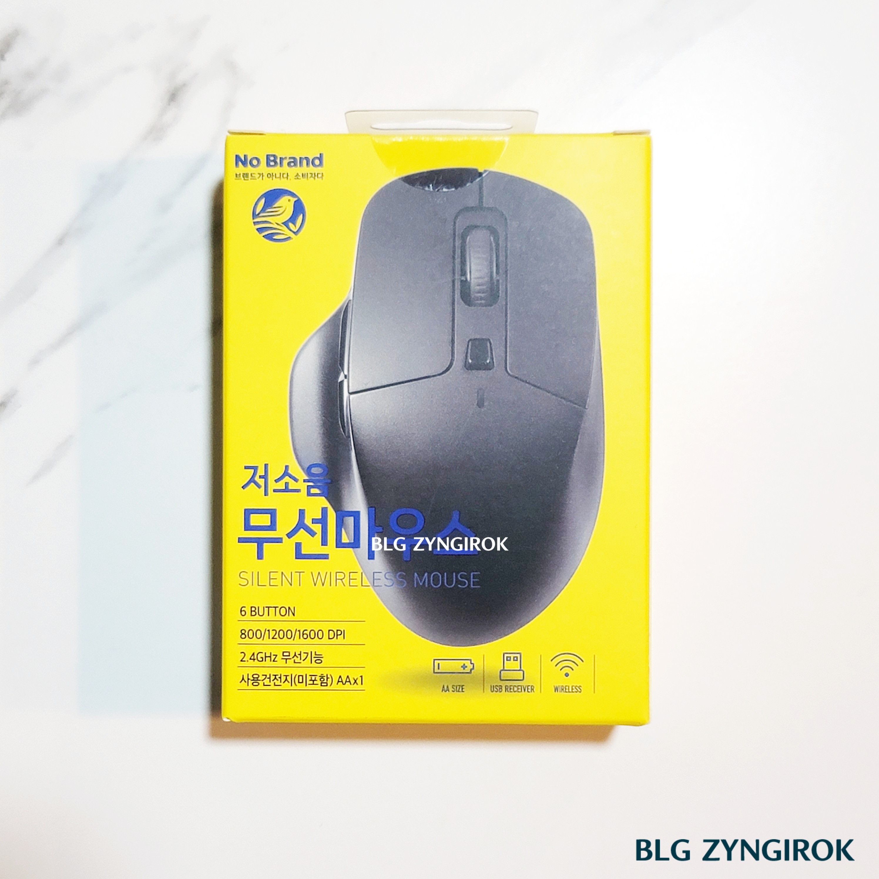 노브랜드 전자기기 : 무선 마우스 상자가 테이블 위에 놓여있다.
