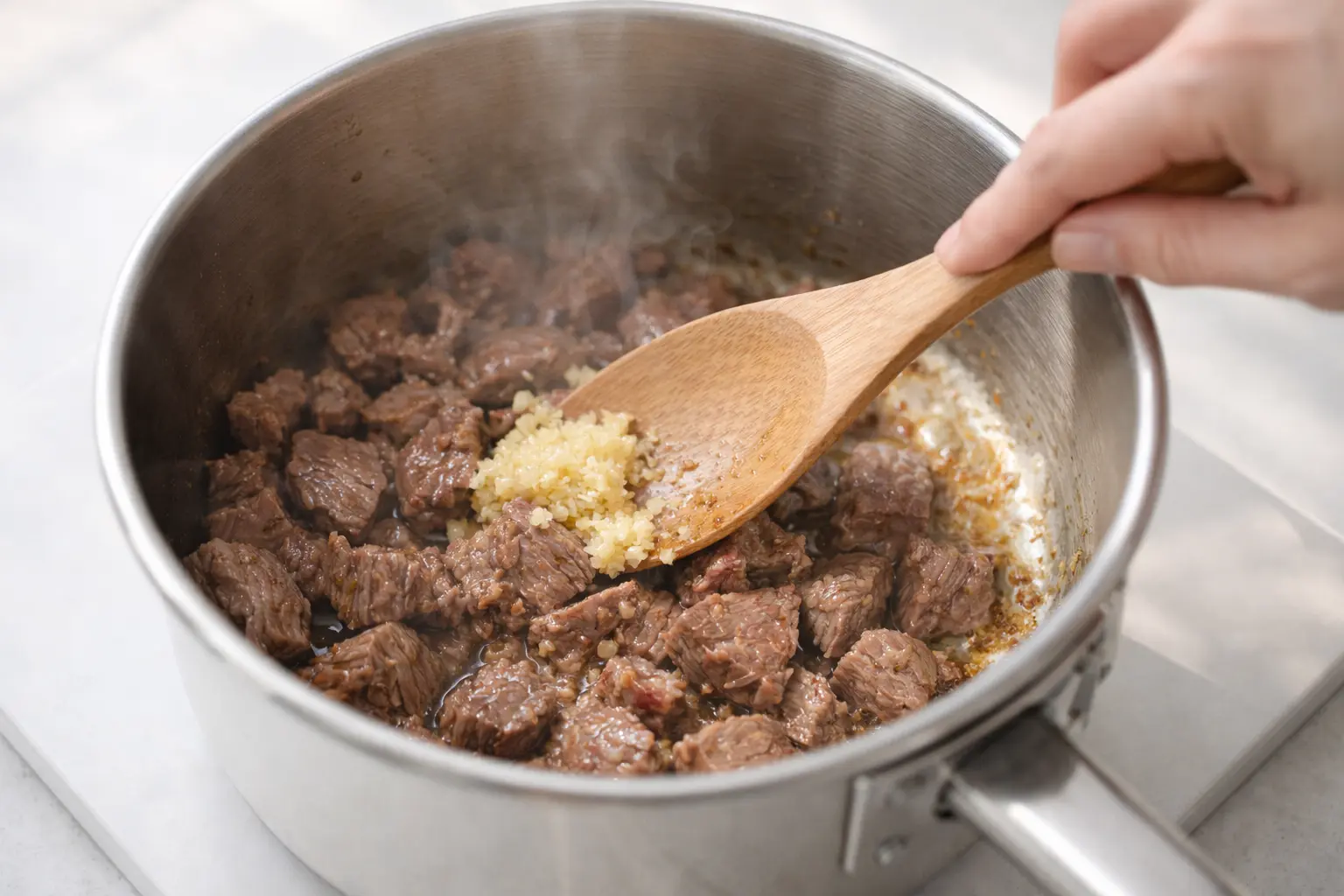 냄비에서 소고기와 마늘을 볶는 떡국 육수 준비 과정