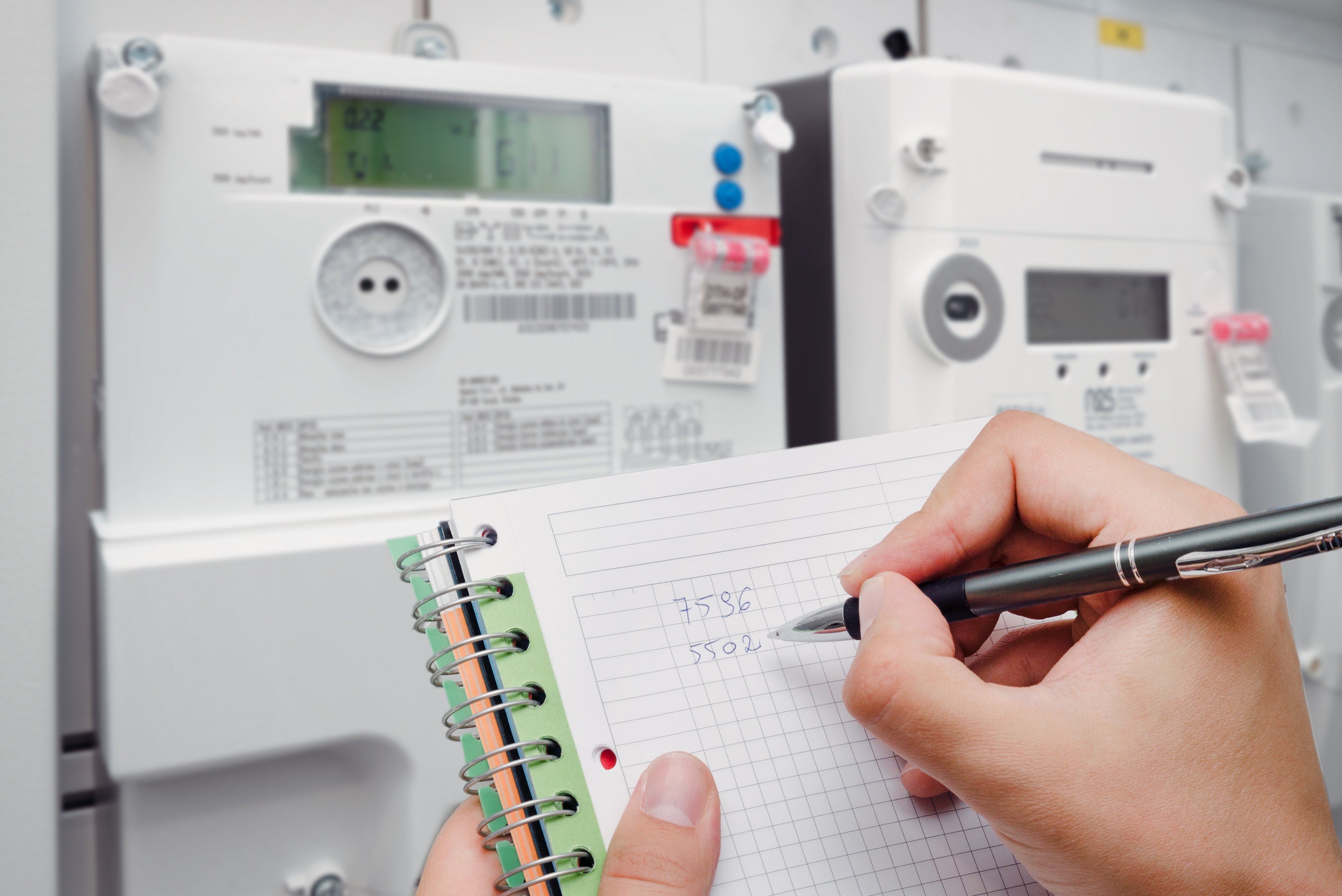 전기 계량기 숫자를 확인하며 노트에 기록하는 모습