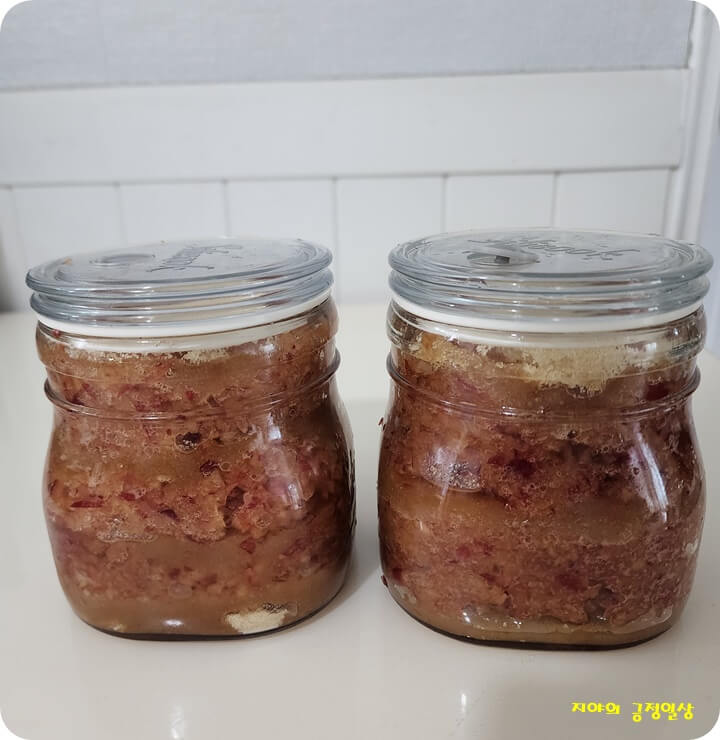 설탕과 간 자두를 번갈아 넣은 유리병