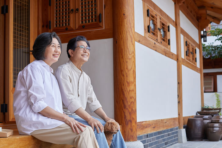 나이든 부부가 한 곳을 바라보며 웃고 있는 사진