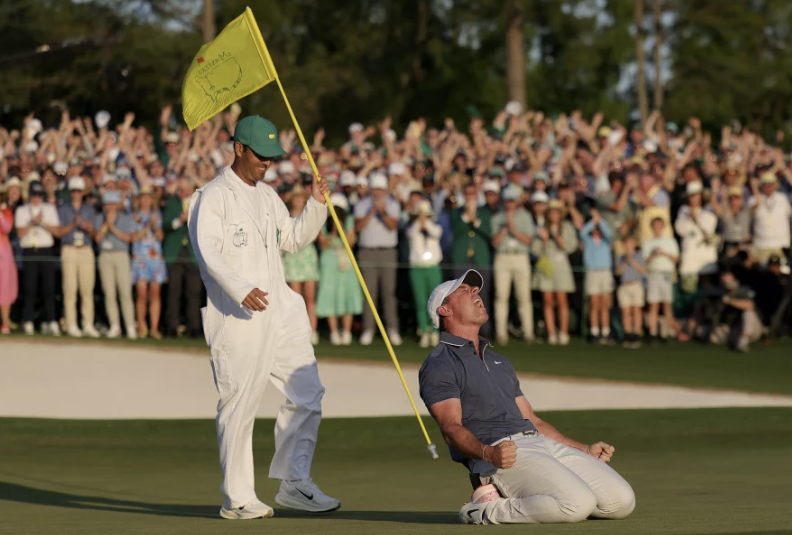 Rory McIlroy of Northern Ireland (R) celebrates winning with caddie Harry Diamond (L) after the playoff hole during the final round of the 2025 Masters Tournament at Augusta National Golf Club on April 13 in Augusta, Ga.