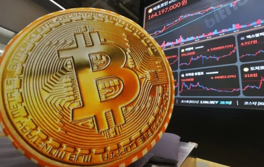 비트코인이 커다랗게 동전속에 있는 모습이 있고 뒤편으로 각종 경제 지표를 나타내는 그래프들이 그래픽으로 펼져져 있다.