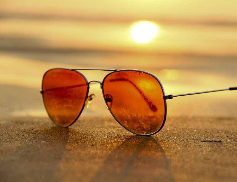 빨간색 안경이 모래 위에 있는 사진