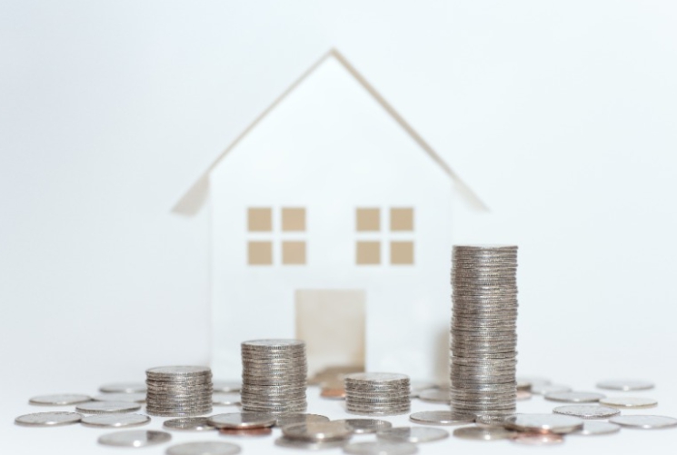 모형 주택앞에 쌓여있는 동전