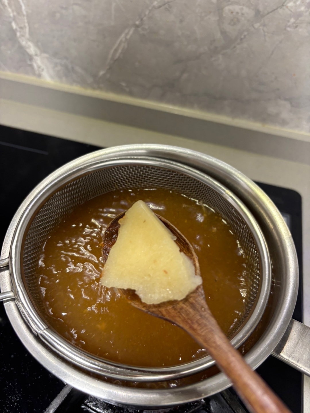 된장이 풀어진 물에 마늘 반 숟가락을 넣으려고 하고 있다