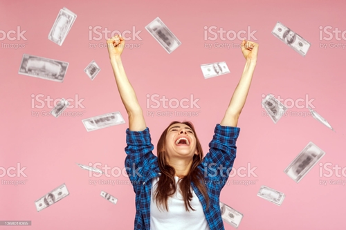 돈이 흩날리고 있는 가운데 두팔 들어 기뻐하는 여자의 모습 사진