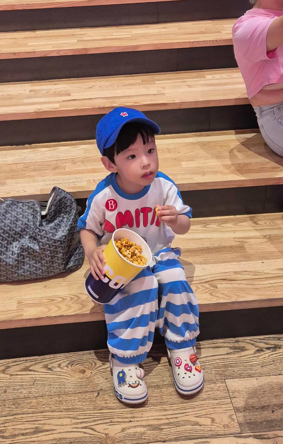 코엑스 영화관 계단에 앉아 팝콘을 먹고 있는 아이의 모습-2