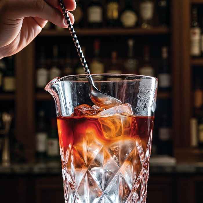 믹싱 글라스에서 진과 포트 와인을 부드럽게 저어 섞는 프린스턴 제조 과정