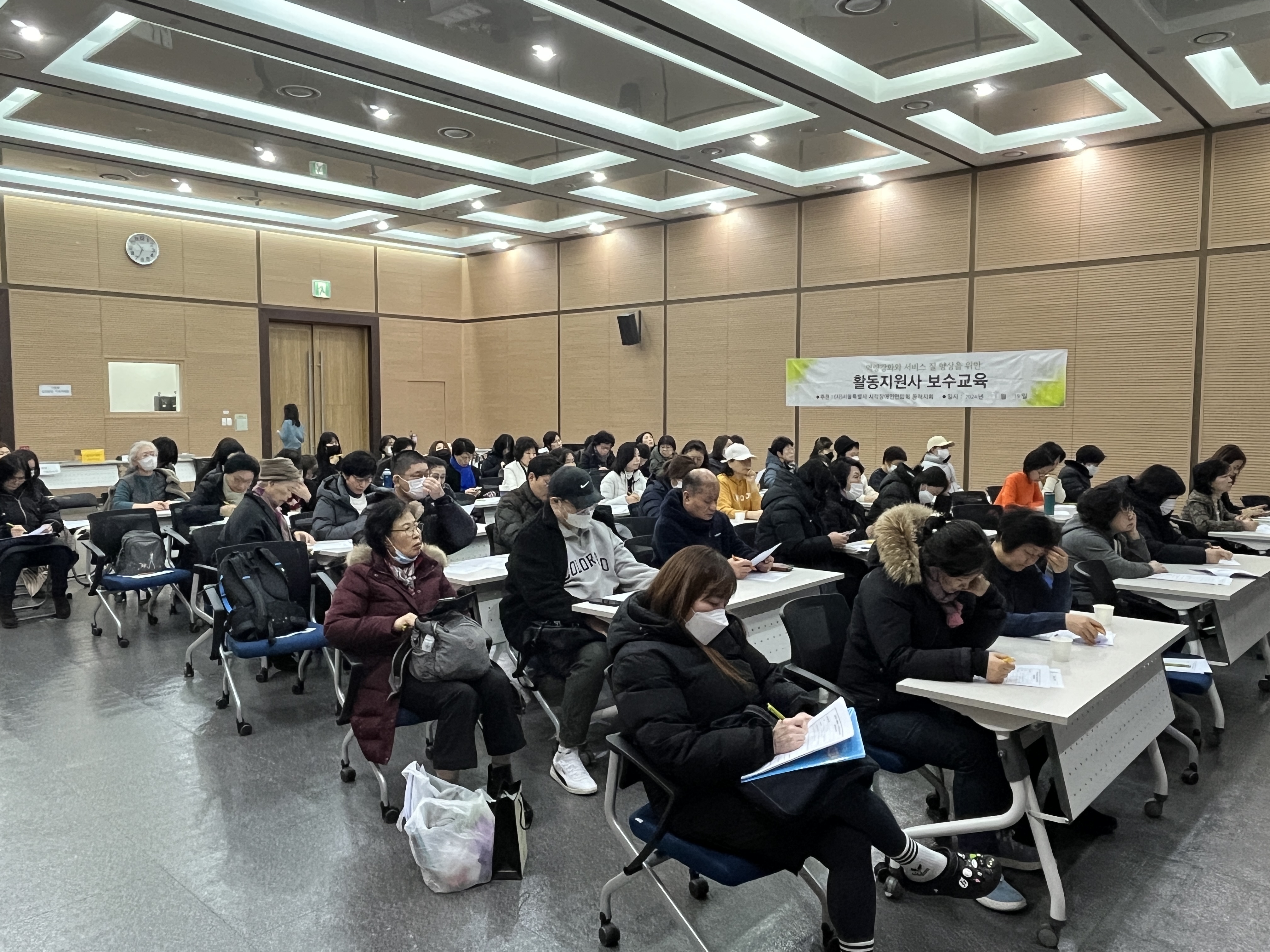 이미지설명: 보수교육에 참석한 활동지원사들이 집중하여 교육을 듣고 있는 모습.