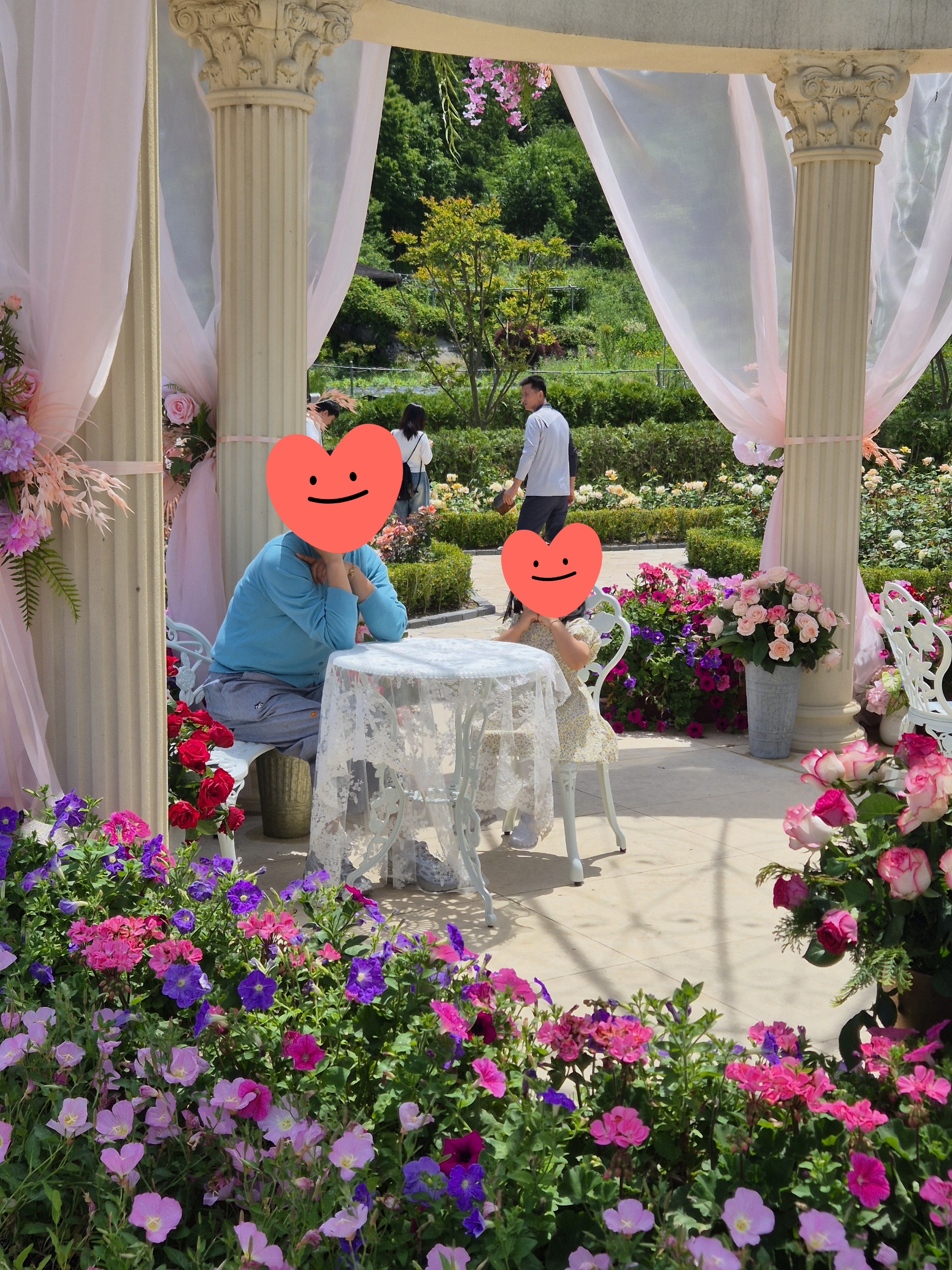 지붕 가득 장미꽃이 피어난 노란 벽 호빗 하우스 앞 오솔길을 뛰어오는 아이