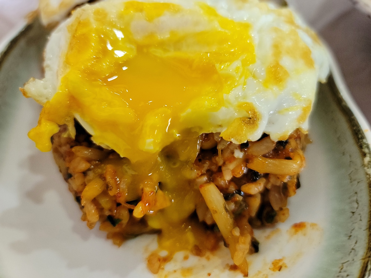 계란반숙이 터트려져 볶음밥 위 노른자가 흐르는 사진