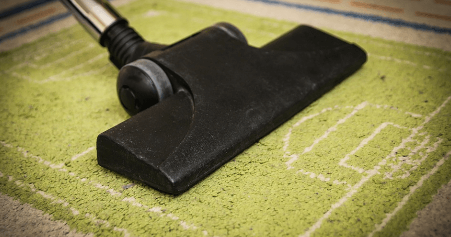 진공청소기로 카펫 청소를 하고 있다