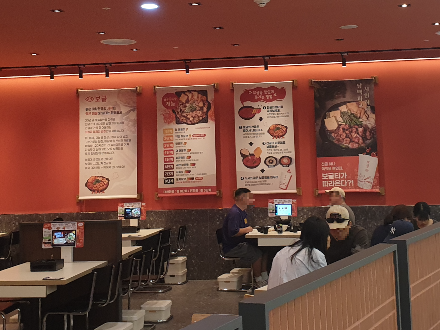 주황색 벽면 발처럼 포스터 4개가 걸려있다.