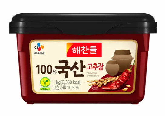 CJ Haechandle 100% Korean Gochujang (1kg) with vegan certification, featuring red chili peppers and traditional onggi pots on the label