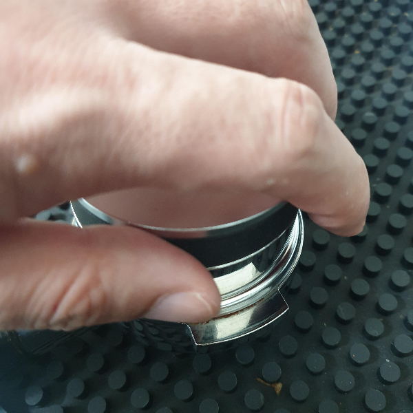 원두가 담긴 포터필터에 디스트리뷰터로 원두를 재분배하고 있다.